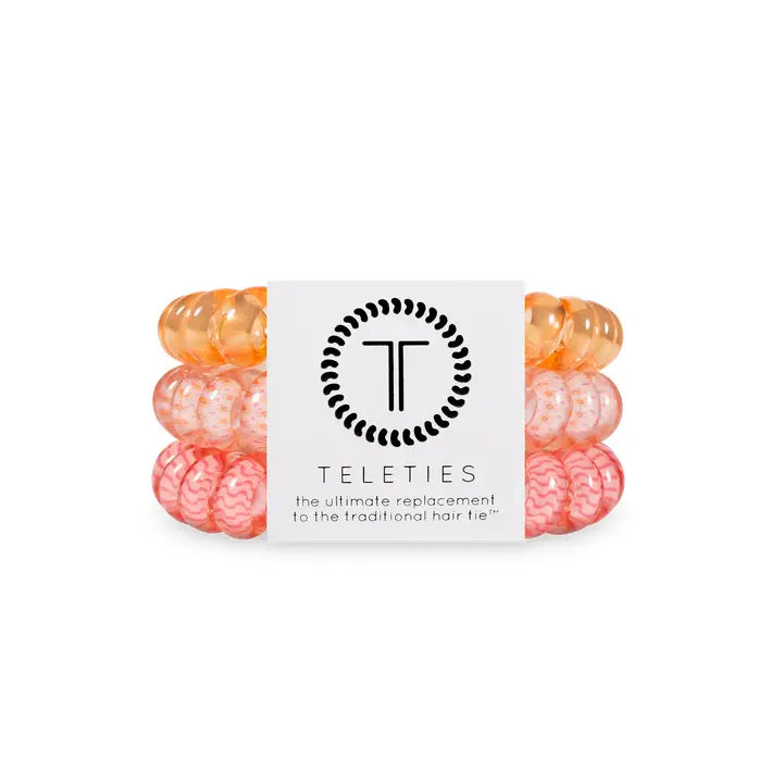 Three TELETIES Hair Ties in orange, light pink, and coral. Available in small and large sizes.