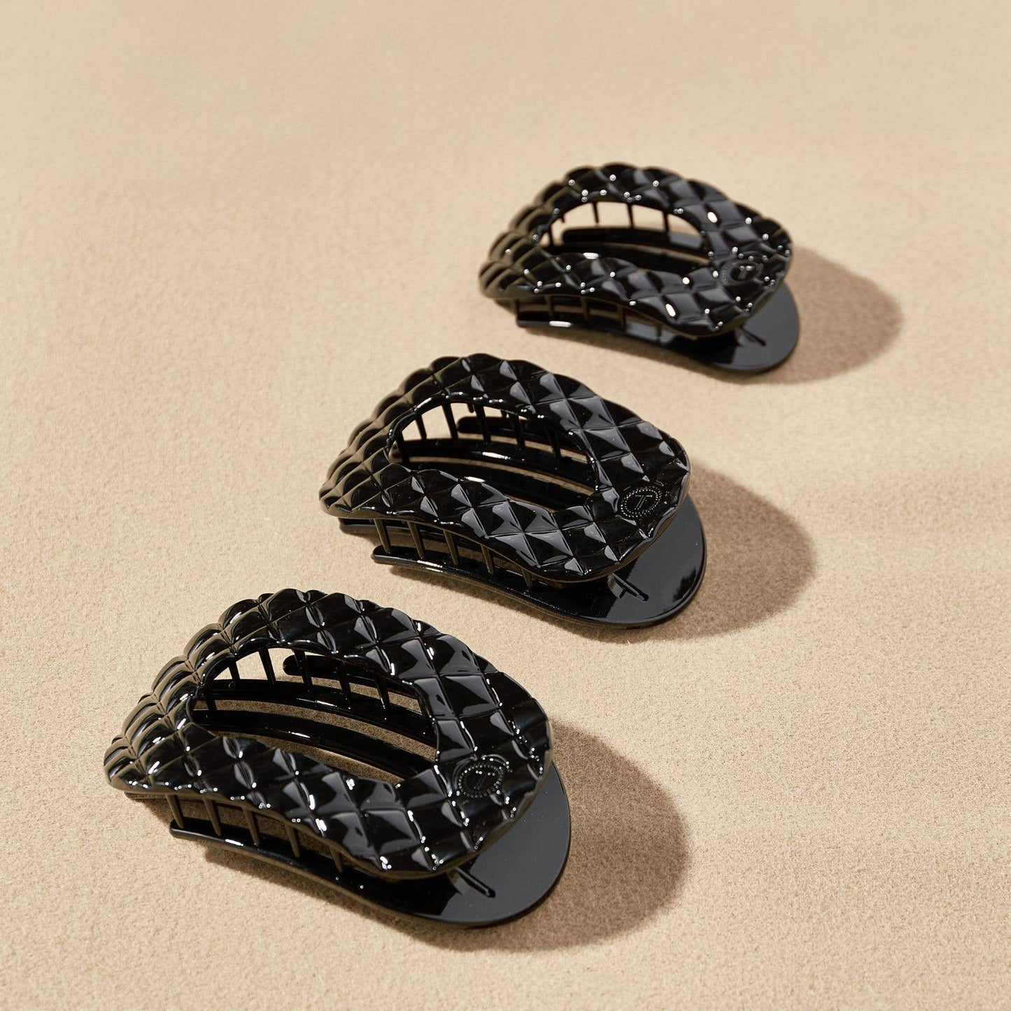 TELETIES Flat Round Hair Clips with a black quilted pattern, available in small, medium, and large sizes.