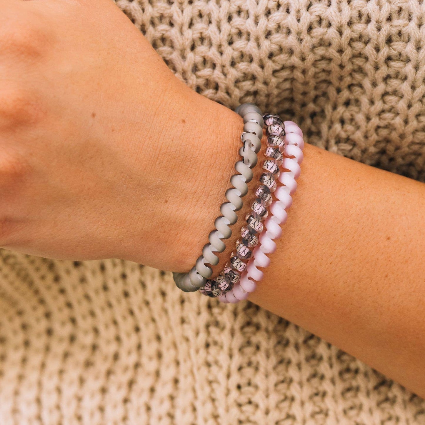 Three beaded bracelets—gray, pink, faceted gray. Available in S/M, M/L sizes.