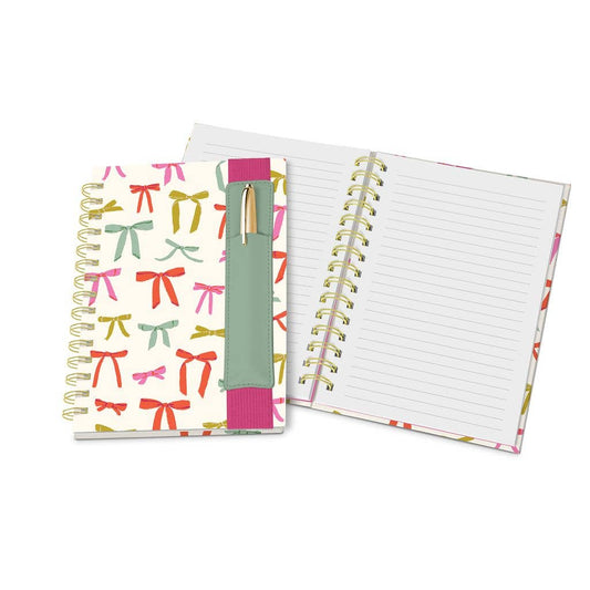 Put a Bow on It Oliver Notebook": colorful bow design, lined pages, vegan leather pen pocket, gold pen. Sizes: N/A.