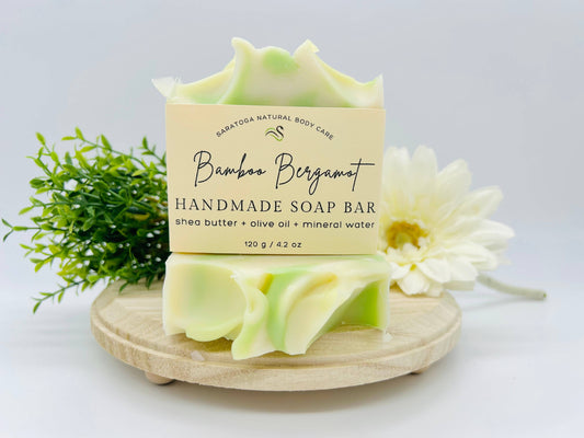 This homemade bar soap has Shea butter, olive oil, and mineral water. The fragrance is bamboo Bergamont. It’s made by Saratoga  Natural body care 4.2 ounces. it is cream edged, and light green