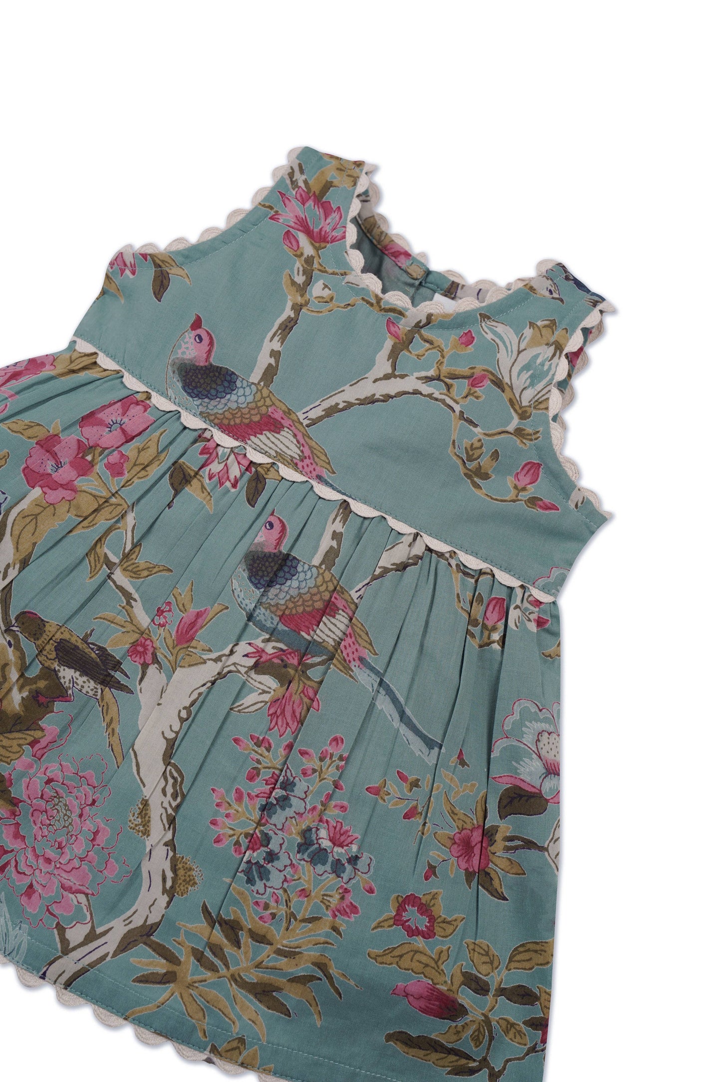 Sleeveless infant dress in sage with scalloped edges, floral and bird prints. Sizes: NB-24M.