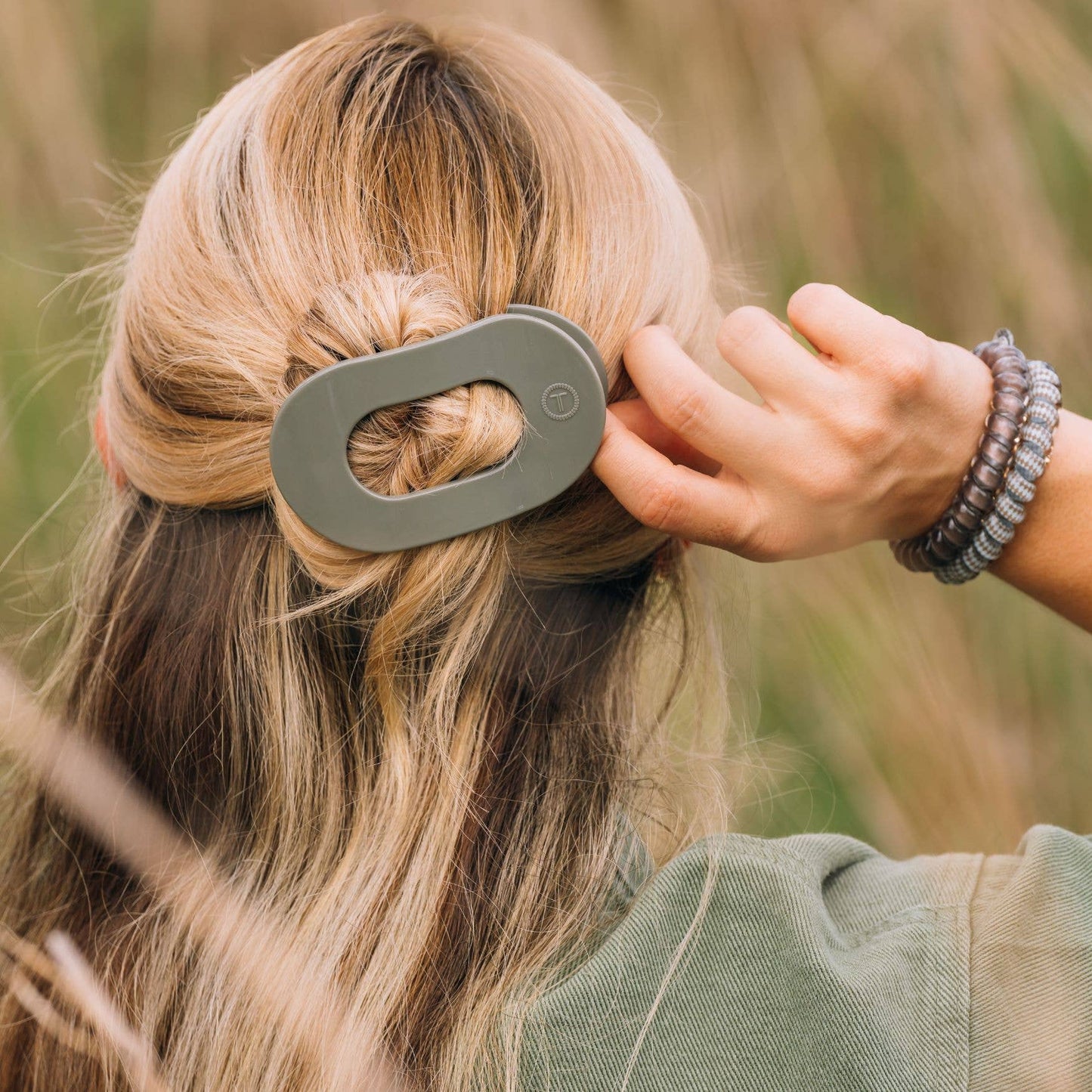 Large gray TELETIES Flat Round Hair Clip shown in use; available in multiple sizes.