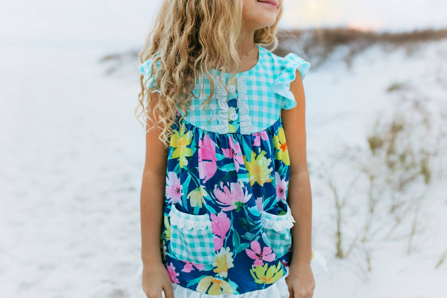 Girls Jade Floral Short Set in blue gingham with floral print, ruffled sleeves, and pockets. Available in sizes 2T-10.