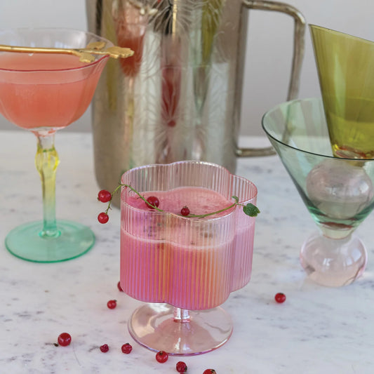 Hand-blown iridescent wine glass with a pleated flower-shaped stem. Available in one size.