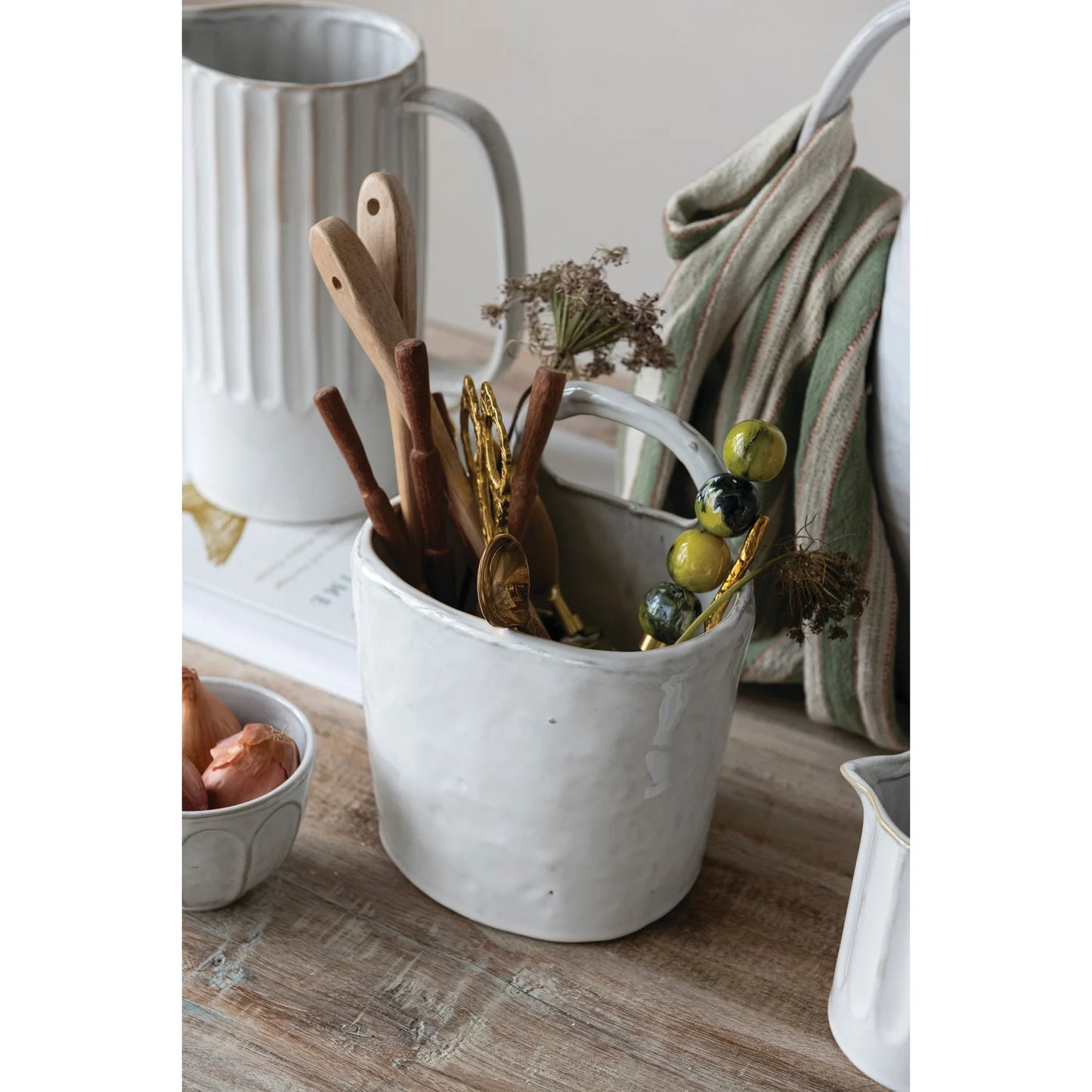 White stoneware crock with handle, each unique, available in various sizes, holds utensils.