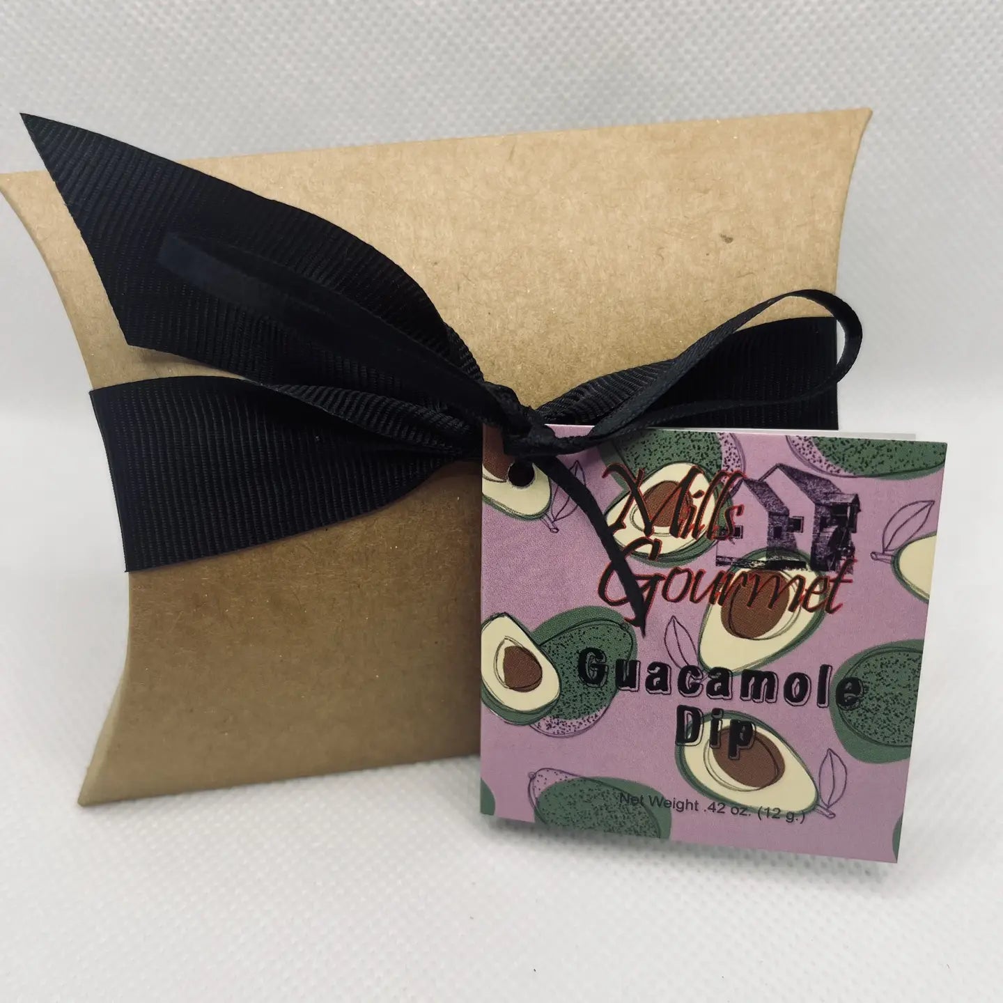 Brown pillow box with black ribbon and "Guacamole Dip Mix" tag; avocado art; 4.2 oz size.