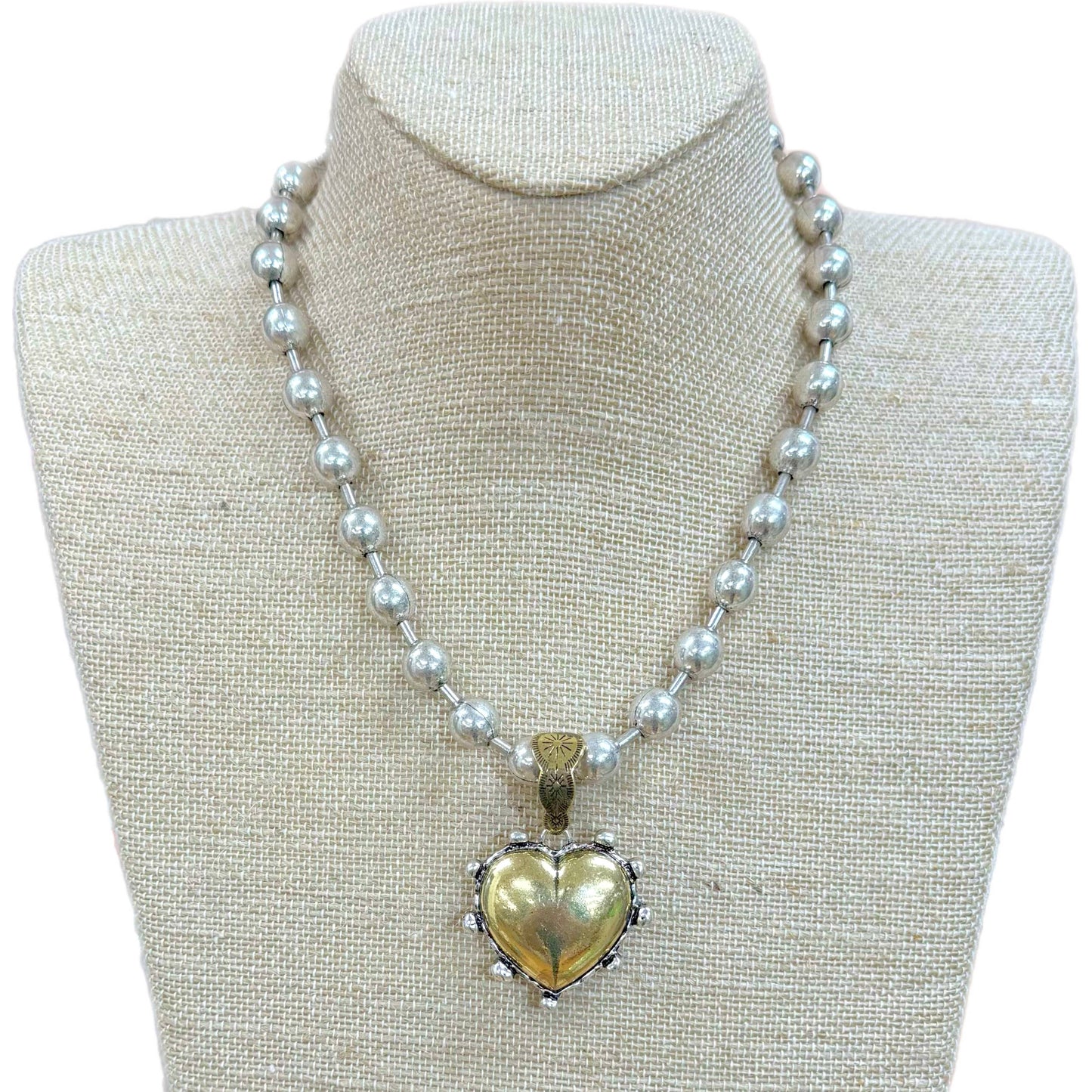 Gold puff heart pendant with decorative details on a round silver ball chain. Available in 16", 18", and 20" lengths.