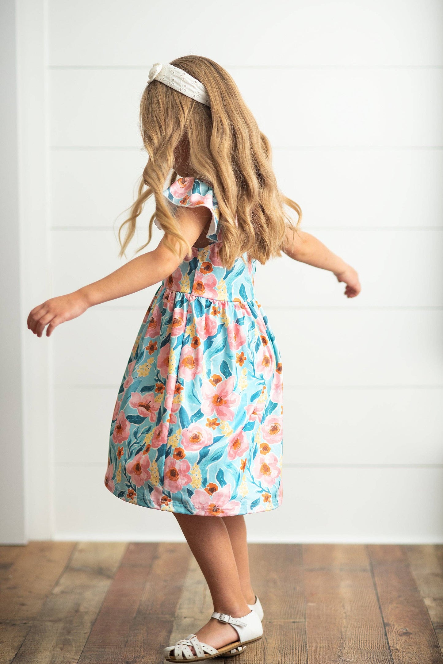 Girls Claire Pink Floral Print Twirl Dress, available in sizes 2T-10, features a vibrant floral pattern and twirl-ready skirt.