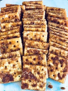 Square crackers coated with Snickerdoodle Cracker Seasoning, available in 4 oz and 8 oz packs.