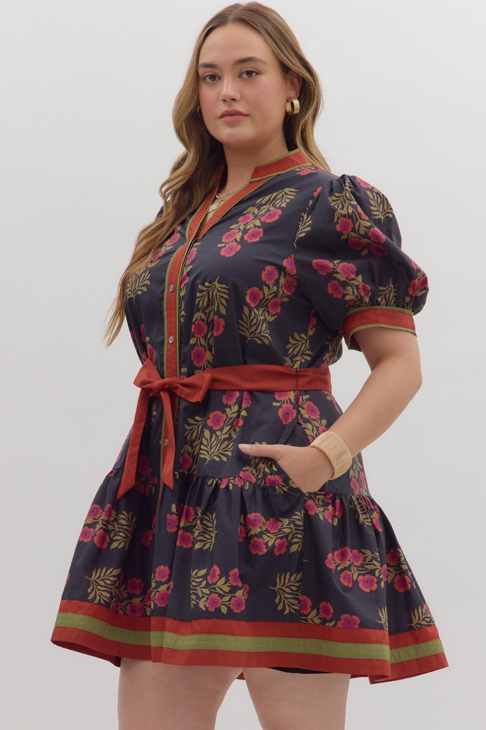 Angie Floral Puff Sleeve Ruffle Hem Dress with red waist tie, gold buttons, green/red trim. Available in sizes XS-XL.