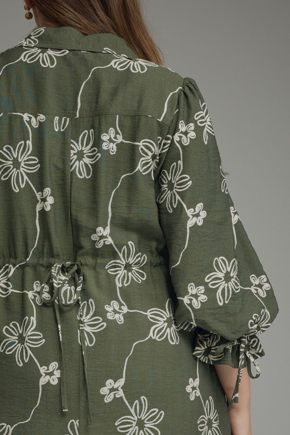 Olive Bloom Tie Waist Dress in olive green with white floral pattern, loose balloon sleeves, tie waist. Available in sizes XS-XL.