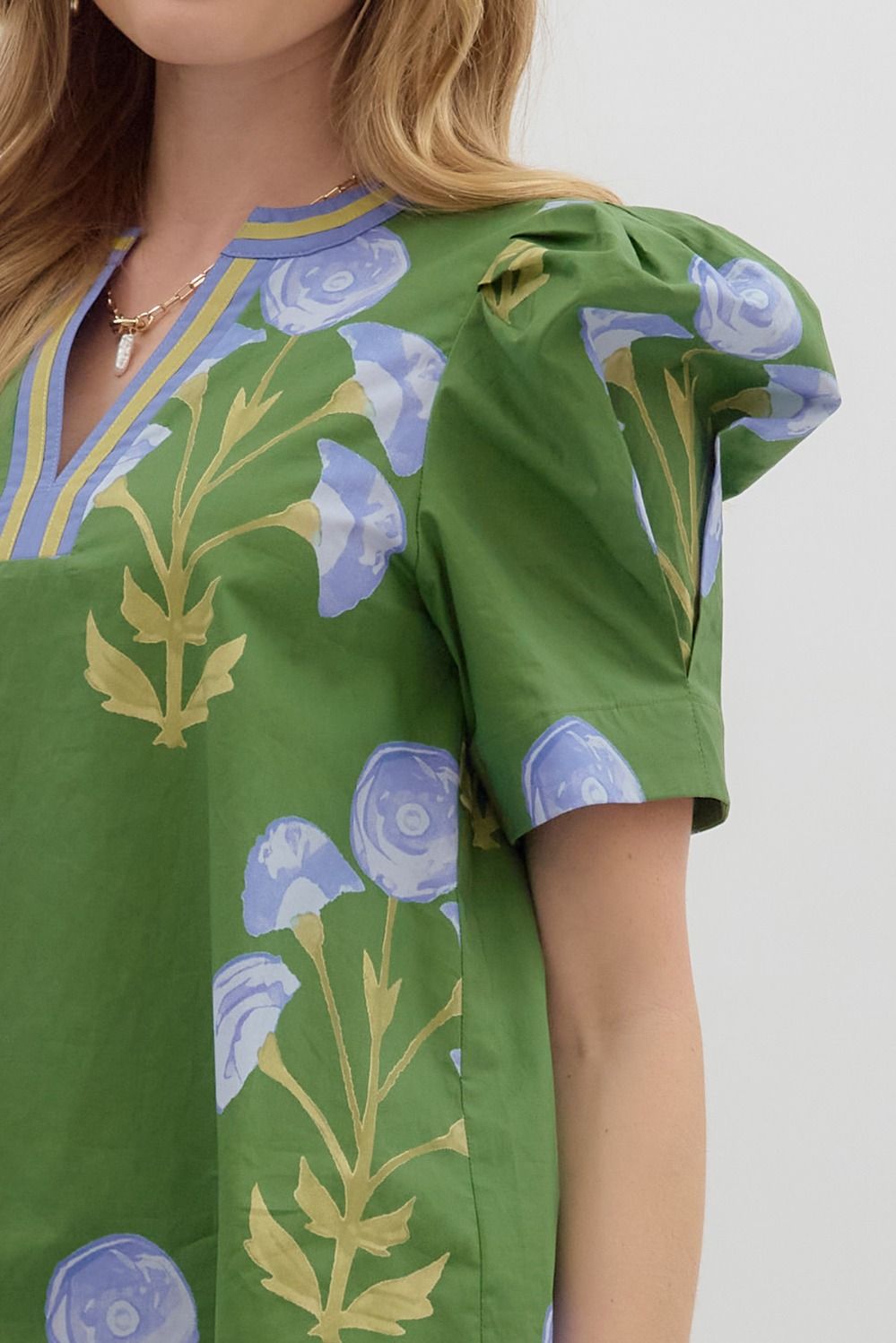 Mabel Blooming Day Top: green floral blouse, puffed sleeves, v-neck with gold trim, blue/beige patterns. Sizes XS-XL.