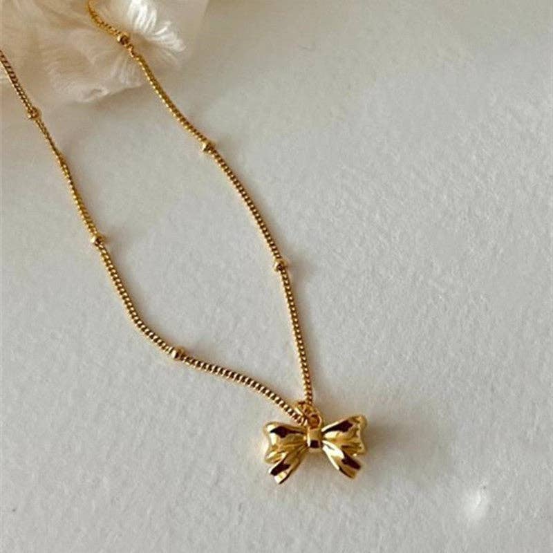 The Dainty Bow Tie Bowknot Charm Necklace in 925 Sterling Silver with a shiny bow-shaped pendant. Available in various sizes.