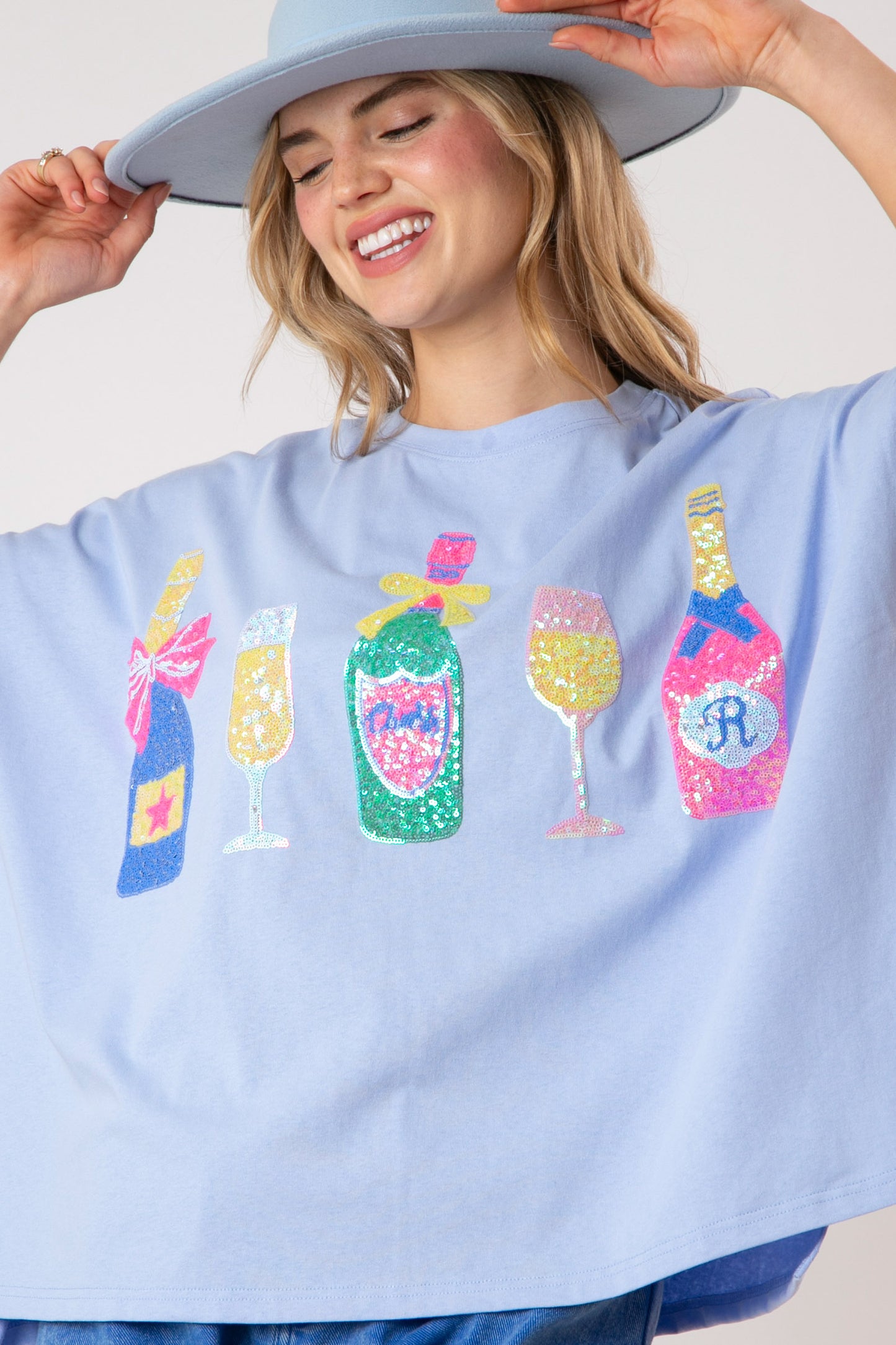 Say Cheers Sequin Loose Fit Top: pastel blue, colorful sequin wine bottle and glass. Available in S-XL.