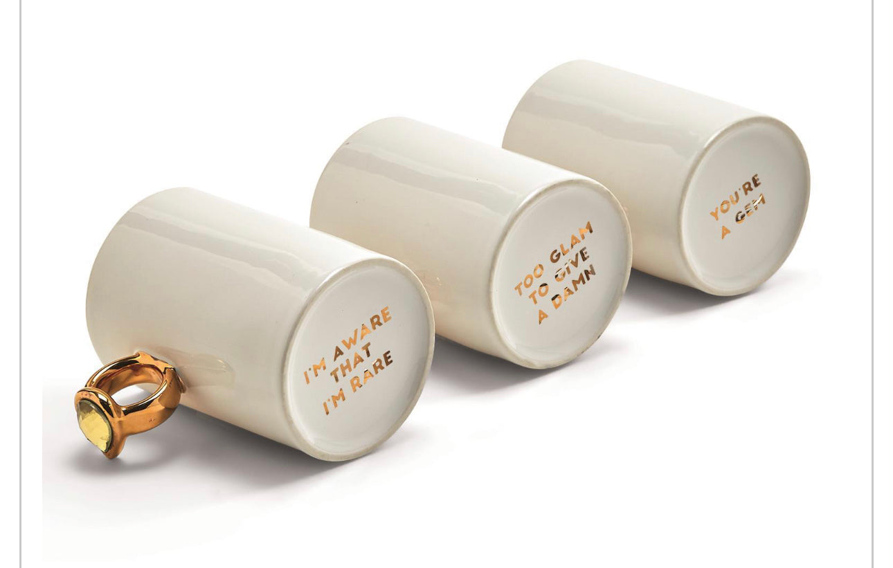 White novelty mug, gold ring gem handle, inside text: "I'M AWARE THAT I'M RARE" etc. Size info not provided.