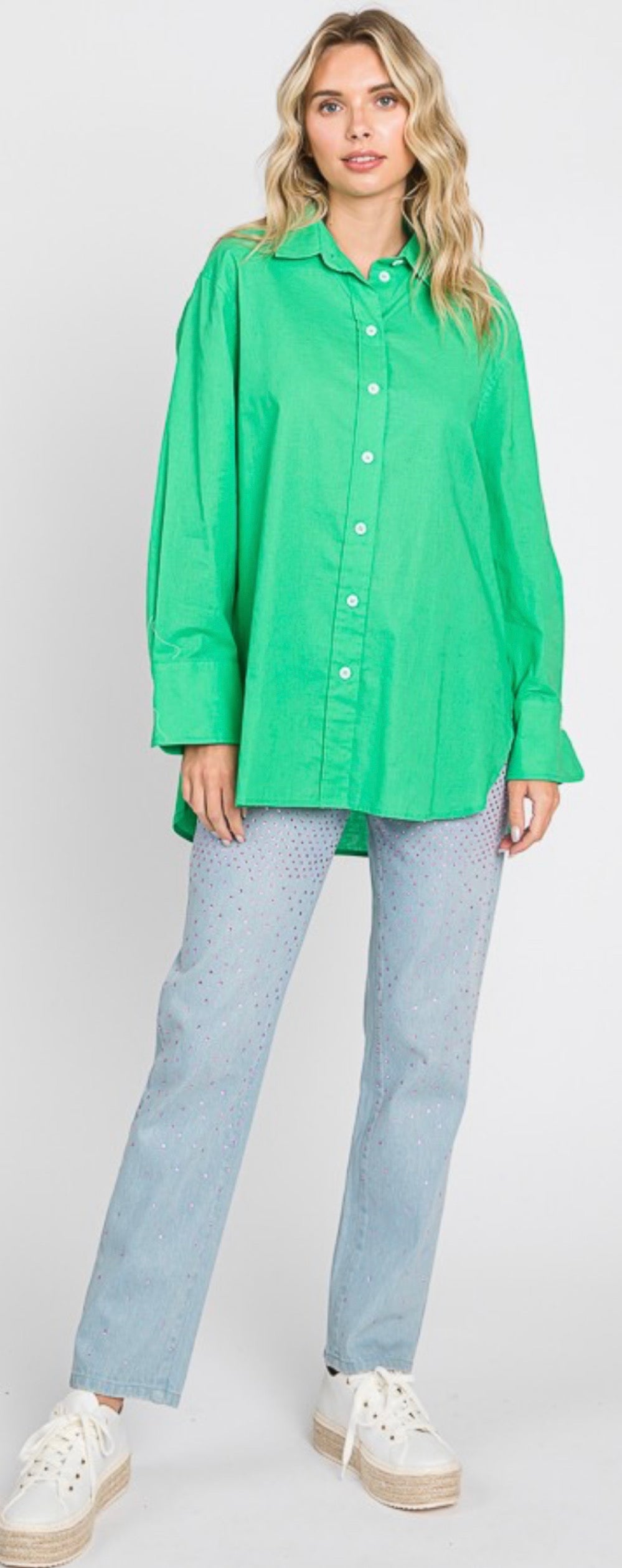 A bright green oversized button-down long sleeve top. Available in sizes S, M, L and XL. Paired here with light blue polka dot pants and white platform sneakers for demonstration purposes only. Pants and sneakers not included with the top.