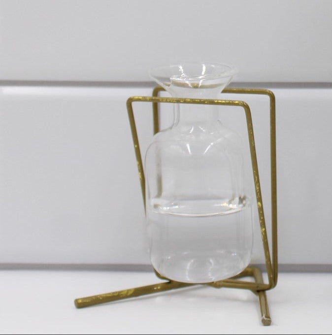 The 3.5" Metal Stand with Glass Vase, Gold, includes a clear vase in a geometric metal stand.