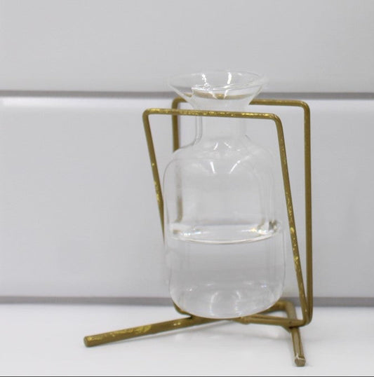 The 3.5" Metal Stand with Glass Vase, Gold, includes a clear vase in a geometric metal stand.