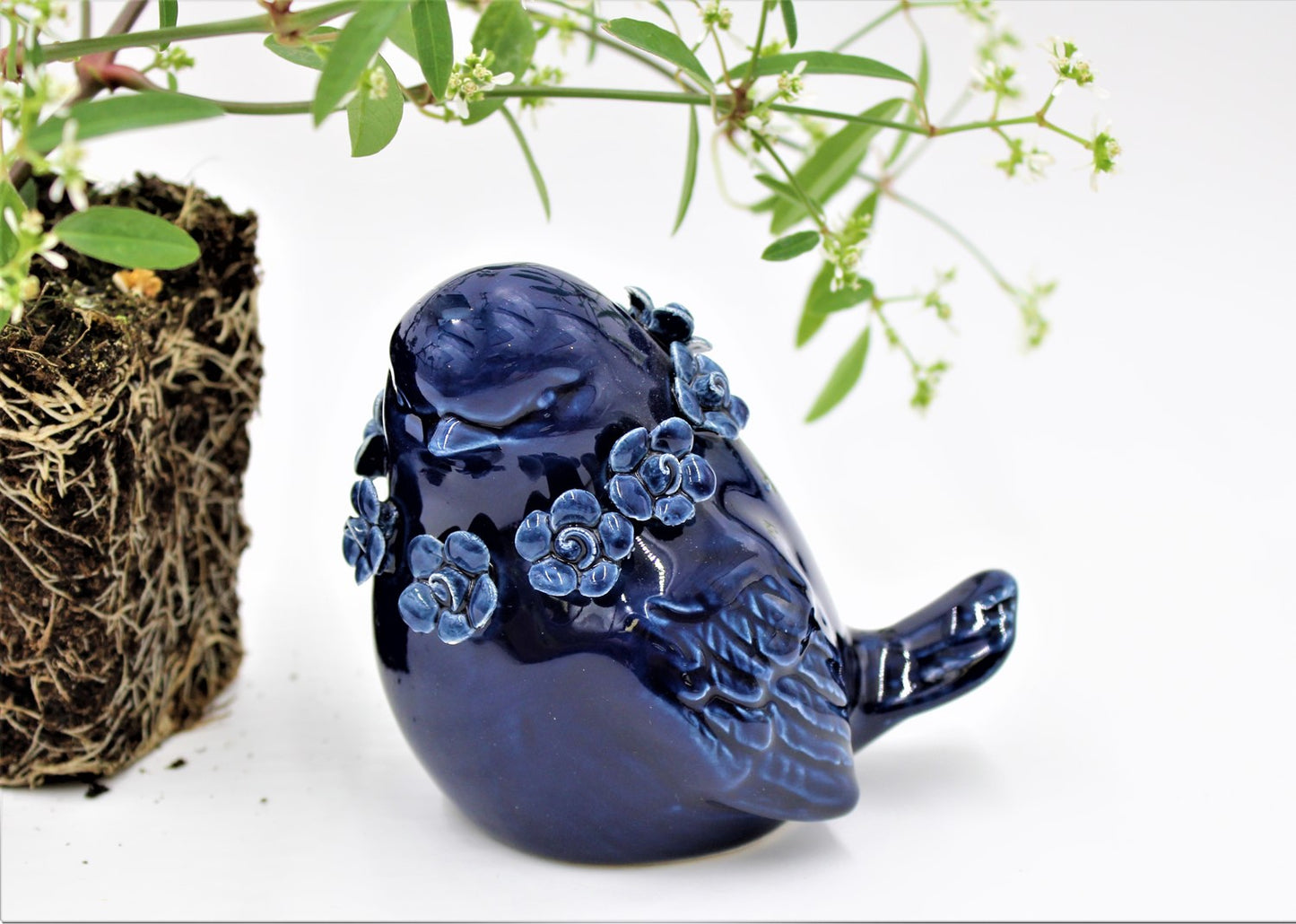 Glossy dark blue ceramic bird figurine, adorned with blue floral patterns. Size: 3x3.5x4". Perfect for gifts or home decor.
