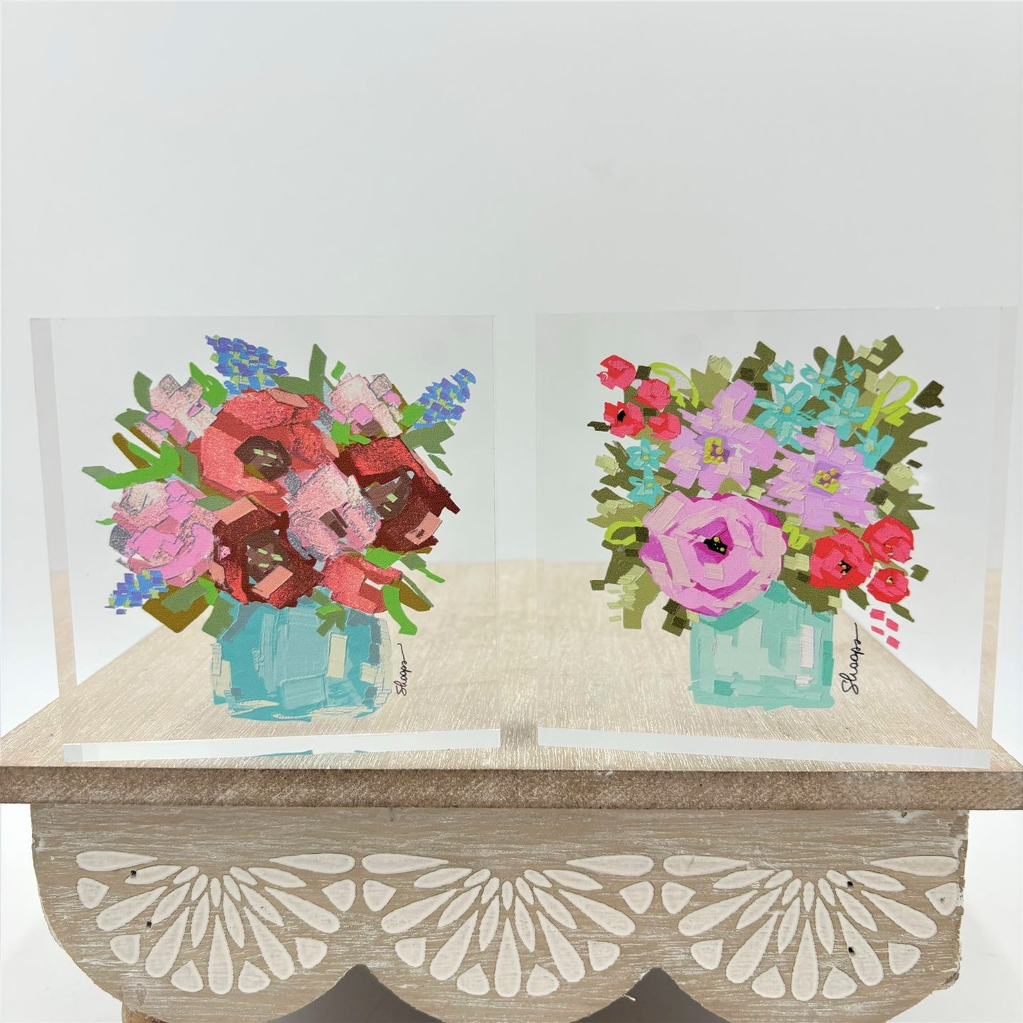 The Flowers in Vase Acrylic Block Sign includes two acrylic flower paintings with a wooden stand. Sizes available: not specified.