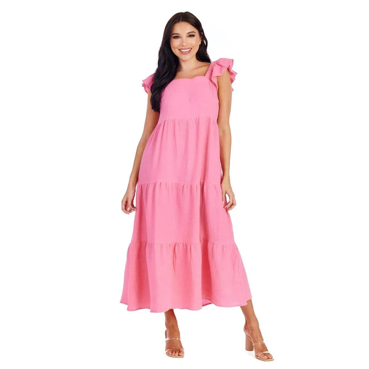 The Blake Maxi Dress is a stylish piece available in pink. It features a tiered skirt and ruffle sleeves for added flair. This dress comes in various sizes to cater for different body types. Please note, this product description does not include the open-toed heels.