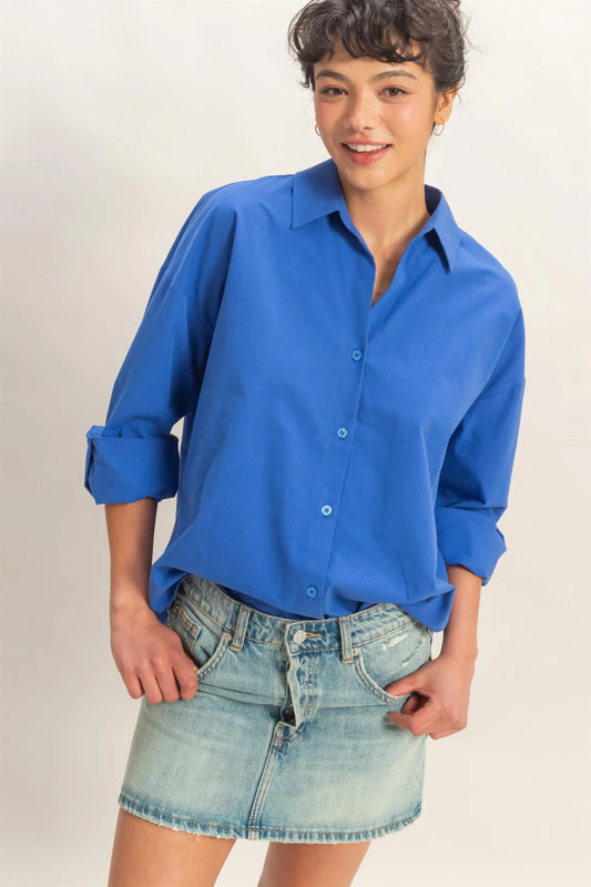 Bright blue Button Up Poplin Shirt with rolled-up sleeves. Available in sizes XS–XL.