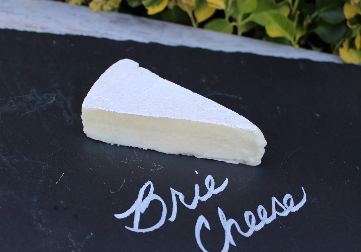 Fake Brie Cheese Wedge, decorative replica available in multiple sizes, realistic details for display.