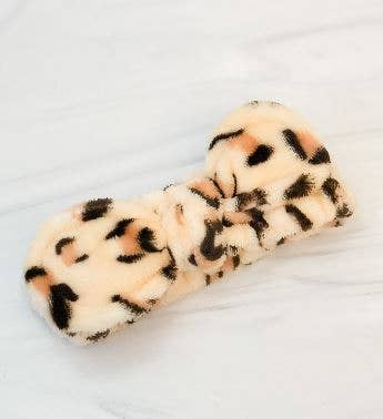 Cheetah Plush Headband with beige, black, and brown leopard print and central knot. Available in standard adult size.