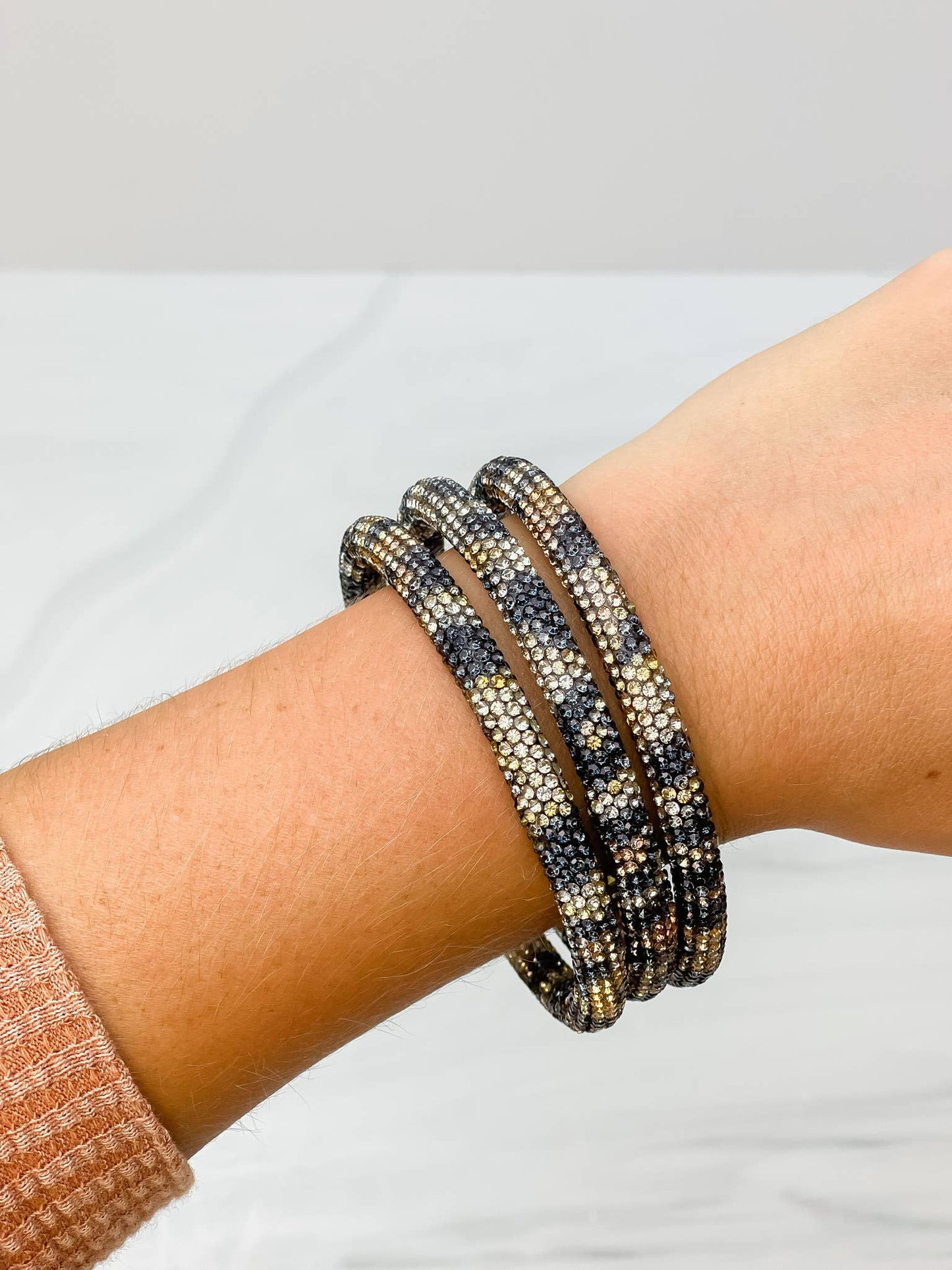 Pave Rhinestone Bangle Set with black, gold, and silver sparkling beads. Available in S/M and M/L sizes.