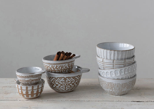 Set of four beige and white Was Relief Pattern measuring cups in various sizes, stacked together.