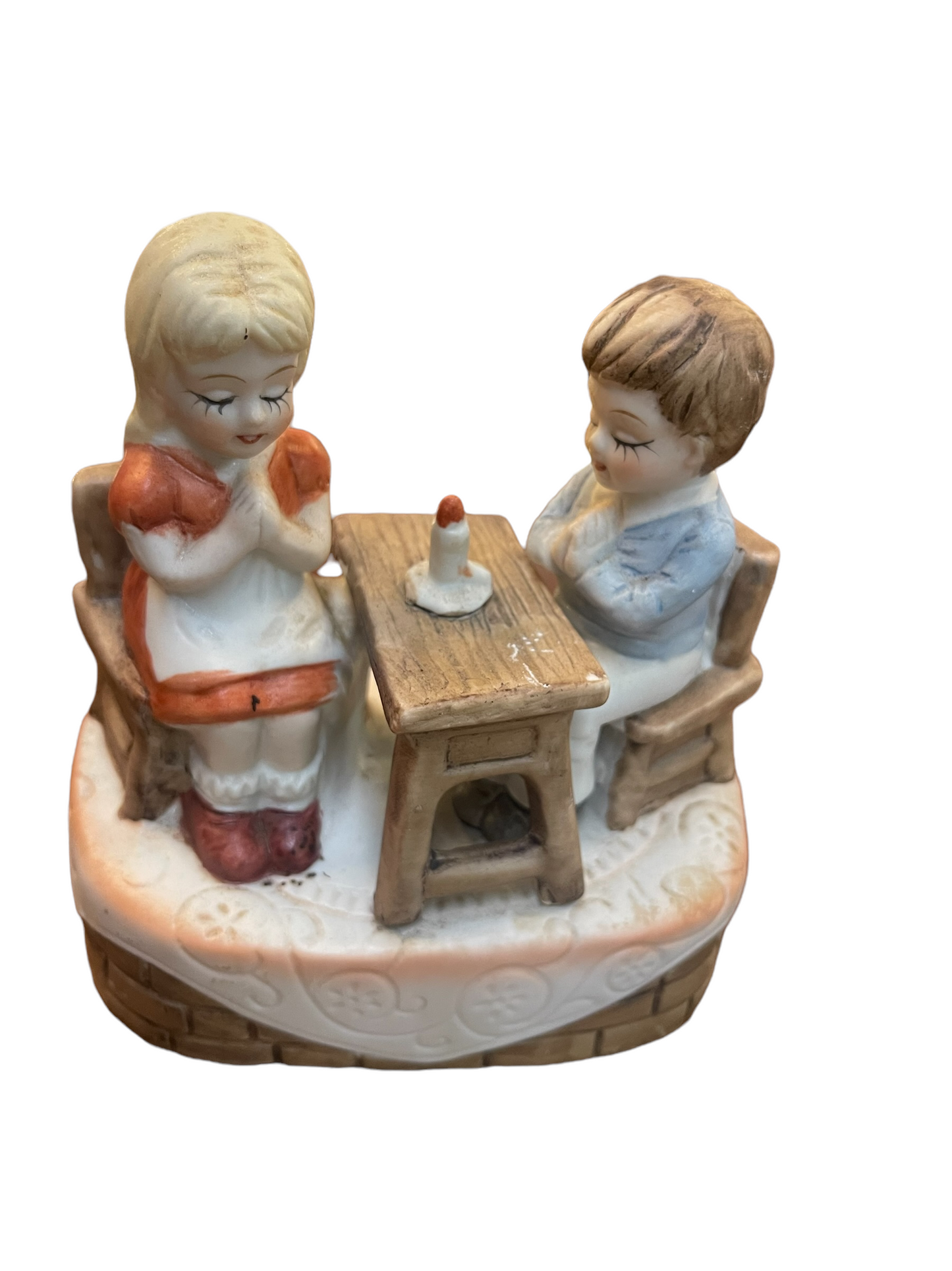 Porcelain music box with praying boy and girl at a table. Decorative oval base. Available sizes: small, medium, large.