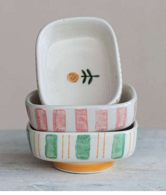 Stacked ceramic bowls: top bowl shows yellow flower; lower bowls have pink and green stripes. Available in three sizes.