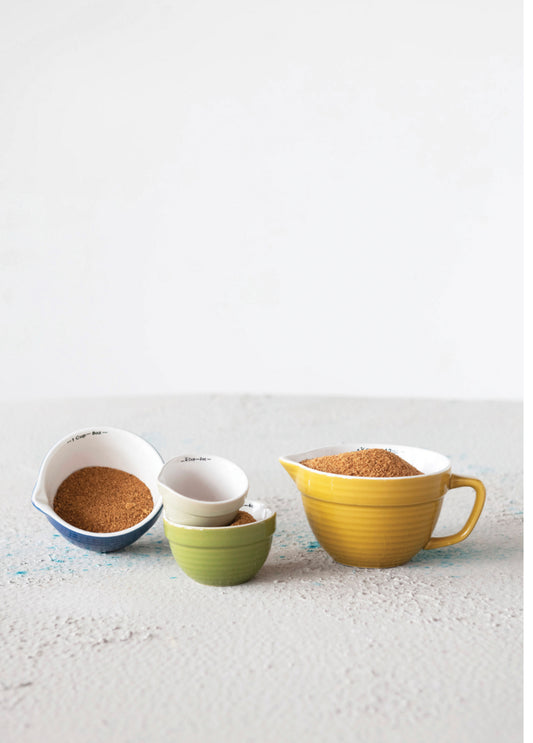 Set of four stoneware batter bowl measuring cups in assorted sizes and colors, available in 1 cup, 1/2 cup, 1/3 cup, and 1/4 cup.