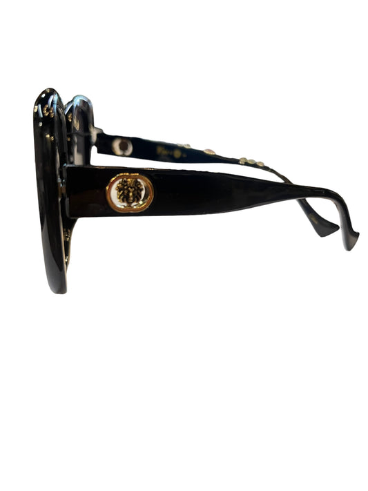 Black Kleo Sunglasses with gold and black lion head emblem on temple, UV 400 protection. Sizes available: S, M, L.