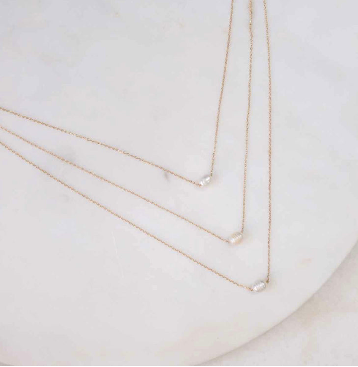 The Simone Pearl Necklace Gold has a delicate gold chain and small pearl pendant. Available in 16", 18", and 20" lengths.