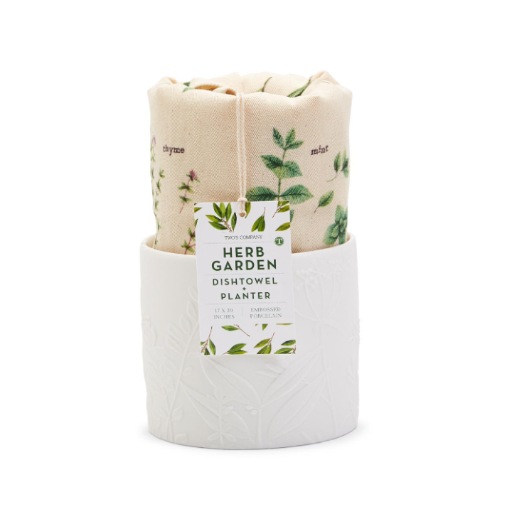White ceramic planter labeled “Herb Garden Dishtowel Planter” with a cream towel featuring green herb illustrations. Sizes vary.