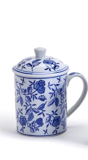 White ceramic mug with handle, matching lid, blue rose and leaf pattern. Available sizes: 53592-20. Classic blue and white design.
