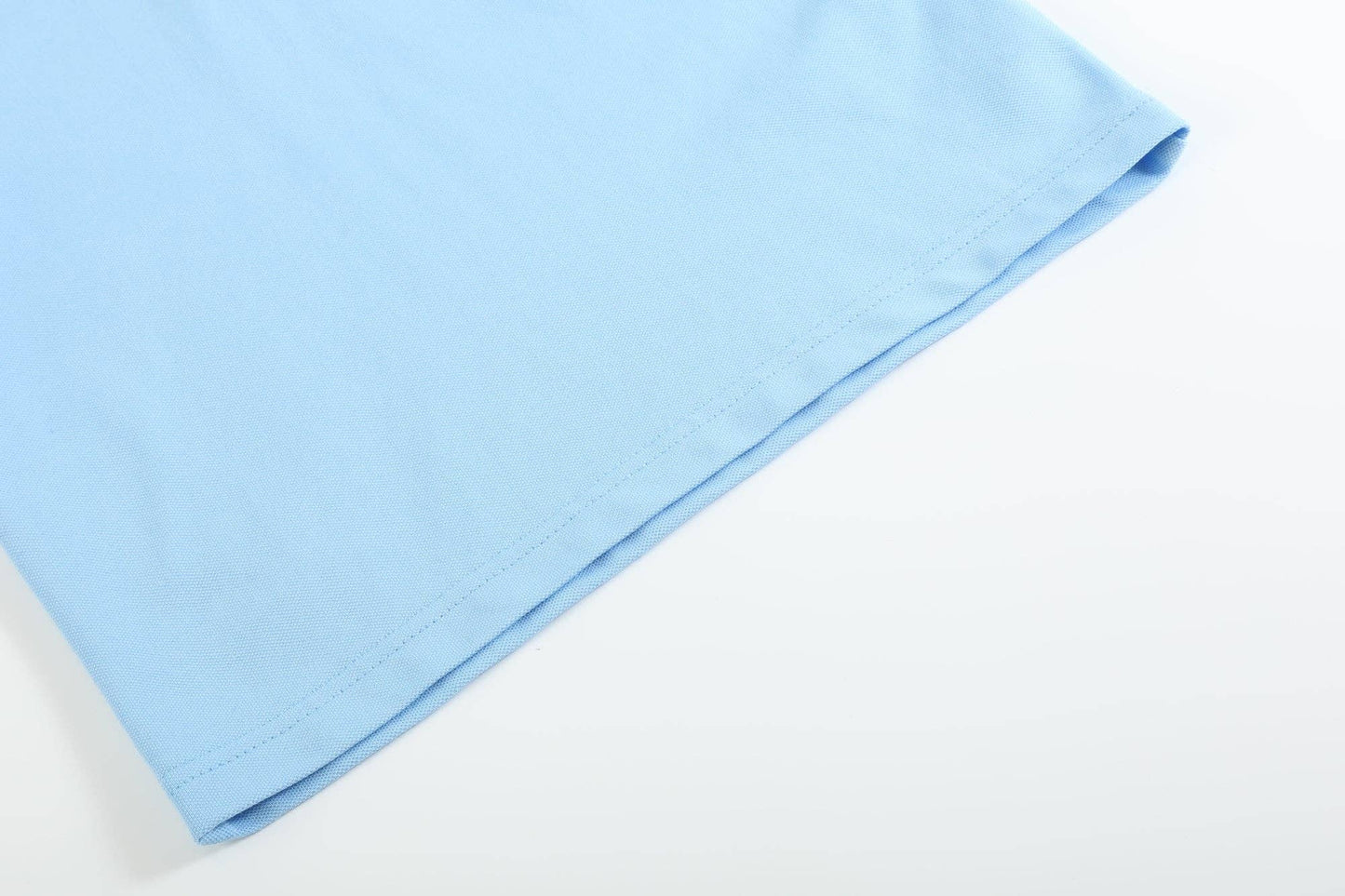 Blue Puppy Polo Golf Shirt, close-up of bottom hem with visible stitching and texture. Available in sizes S, M, L, XL.