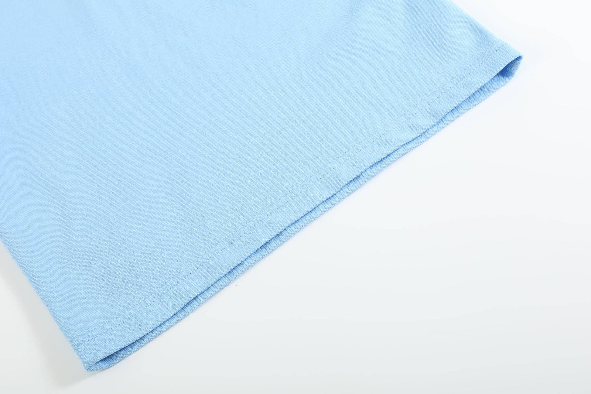 Blue Puppy Polo Golf Shirt, close-up of bottom hem with visible stitching and texture. Available in sizes S, M, L, XL.