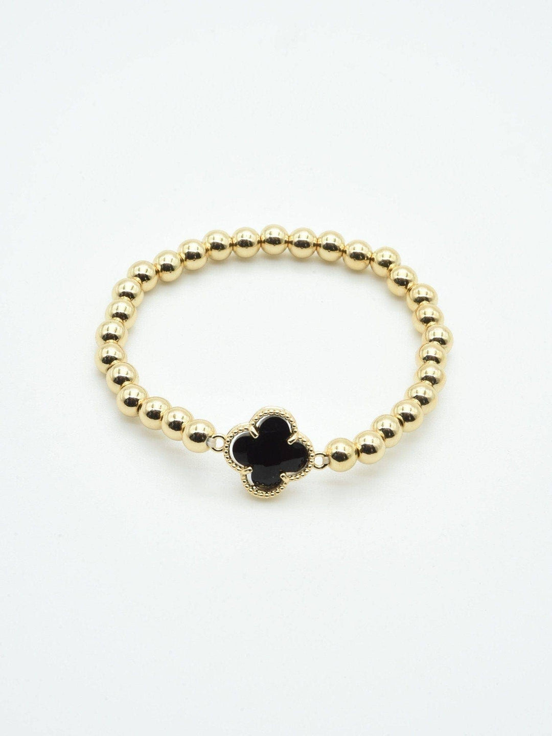 Gold beaded bracelet with a black crystal clover charm. Available in sizes S, M, L.