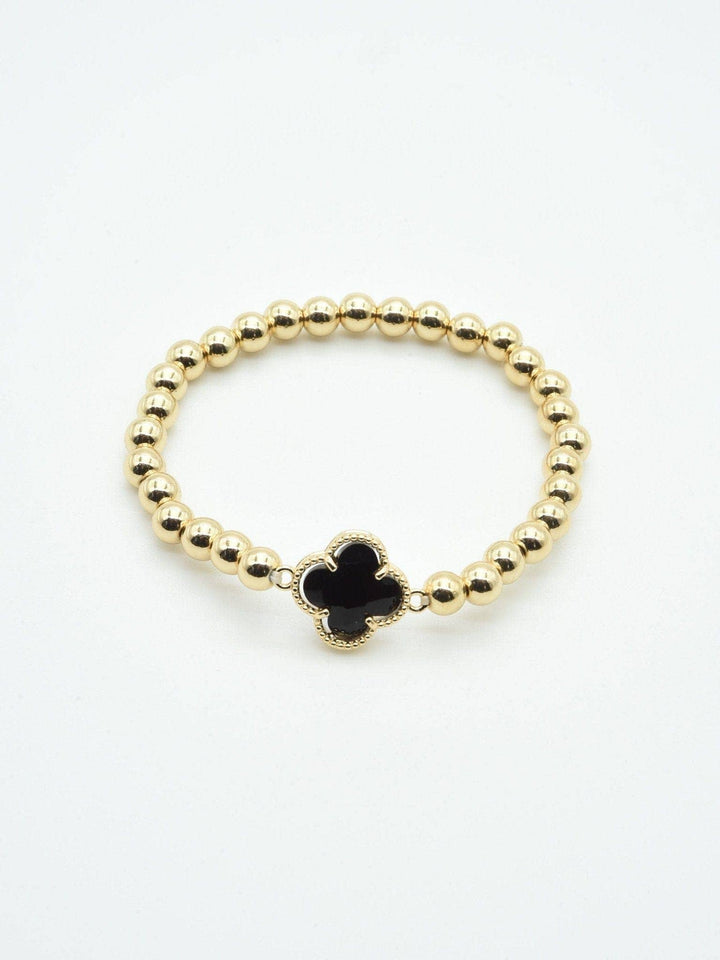 Gold beaded bracelet with a black crystal clover charm. Available in sizes S, M, L.