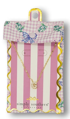 Small gold initial on a round pendant. Available sizes: one size. Comes with a pink gingham pouch and striped card.