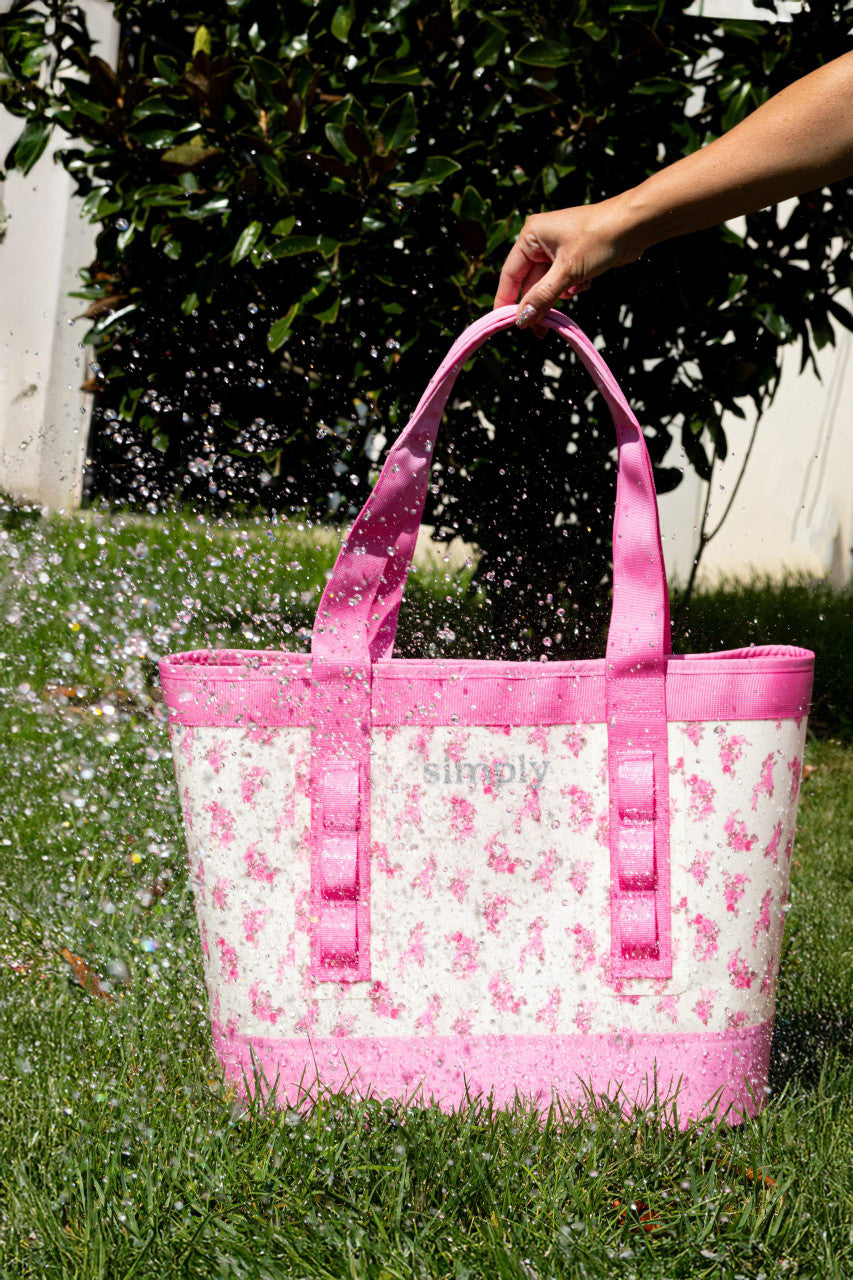 Simply Tough Tote in pink floral, water-resistant, shown with water splashing. Available in 5 colors and multiple sizes.