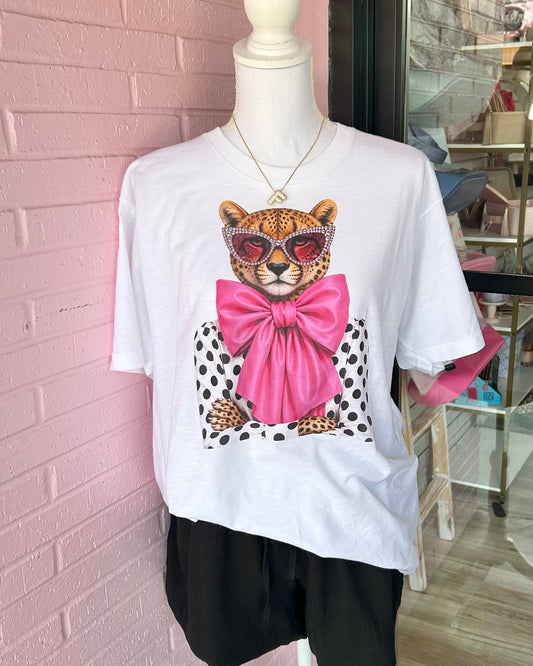 Pink Bow Leopard Tee: white shirt with cheetah in leopard rhinestone sunglasses, hot pink bow, and playful polka dots. Available in sizes S-XL.