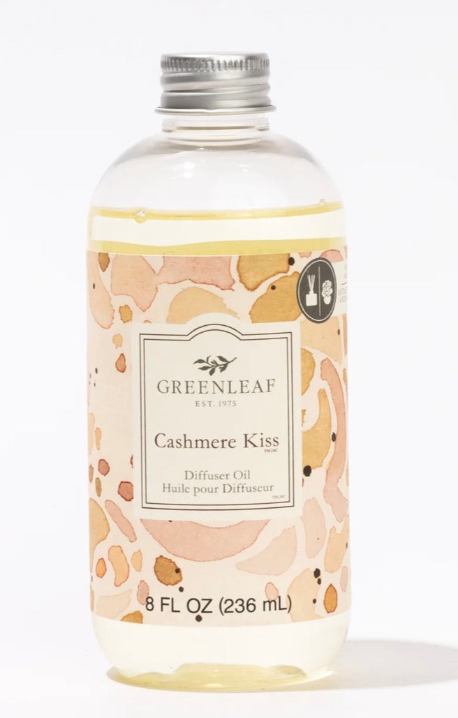 Clear bottle of "Cashmere Kiss Diffuser Oil," 8 fl oz (236 mL), with a peach and beige label, holds light yellow liquid.
