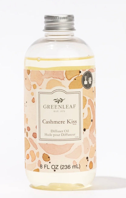 Clear bottle of "Cashmere Kiss Diffuser Oil," 8 fl oz (236 mL), with a peach and beige label, holds light yellow liquid.