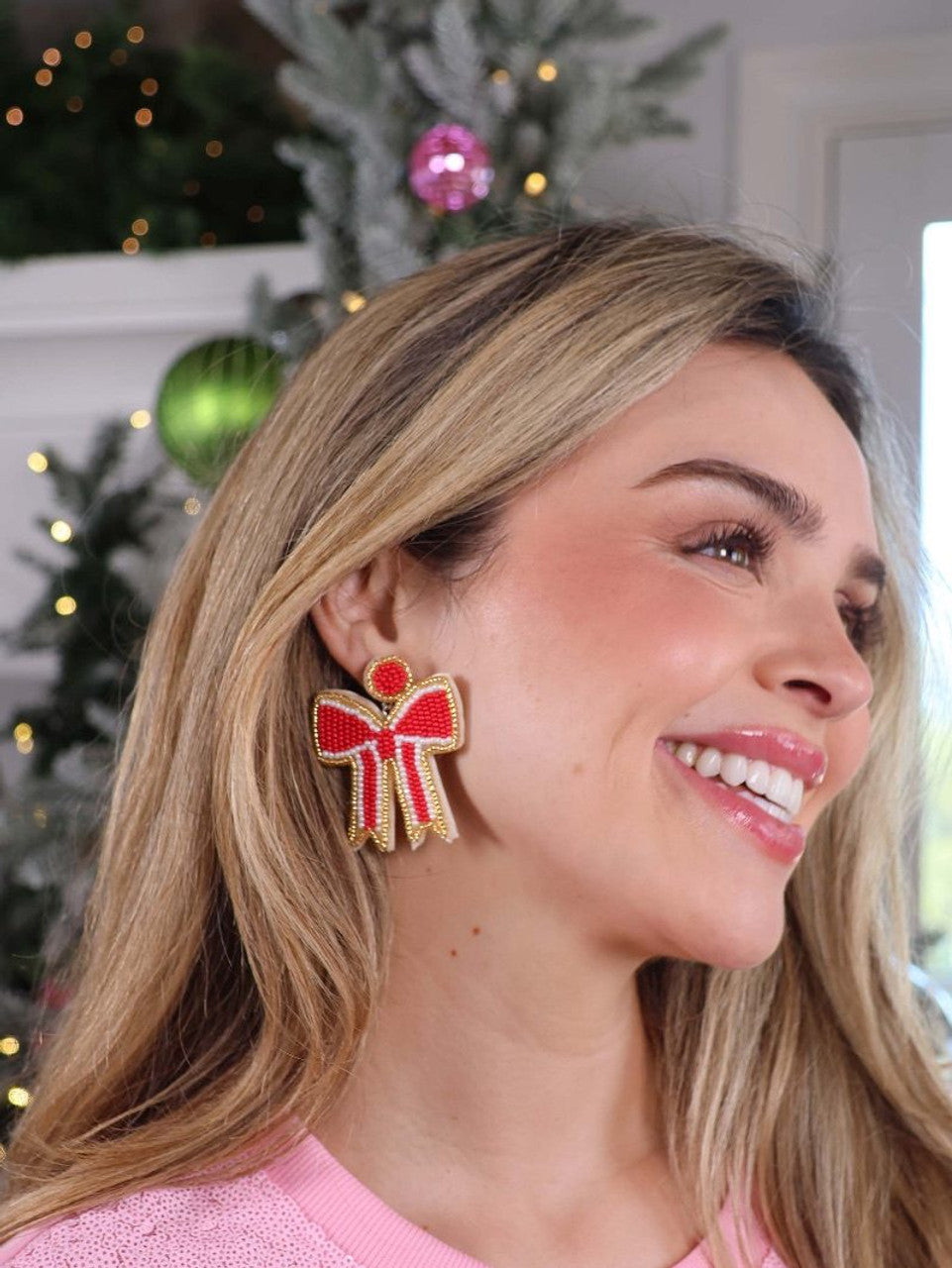 Red and white bow-shaped beaded holiday earrings.