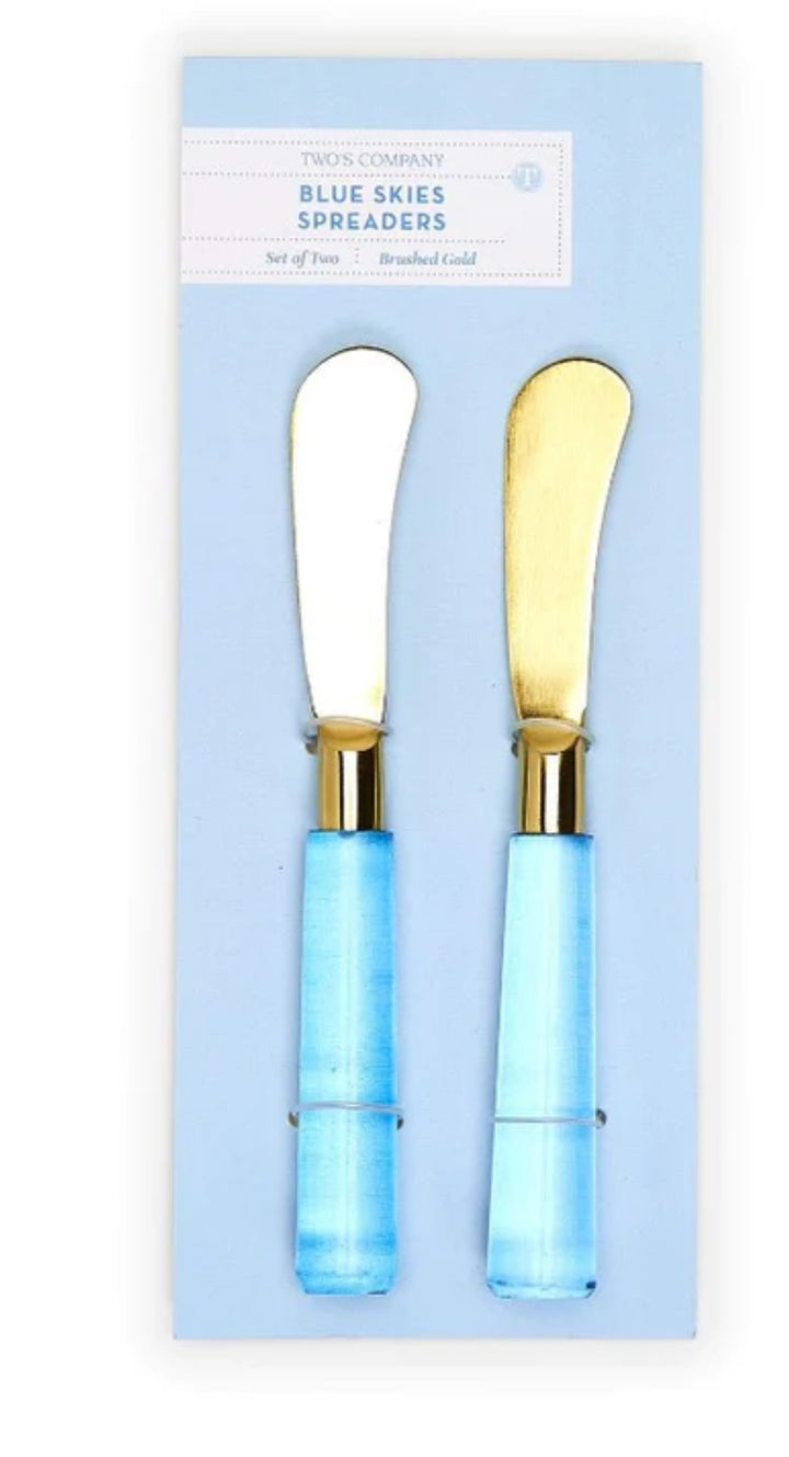 Set of two cheese spreaders with brushed gold blades and glossy light blue handles. Available in standard size.