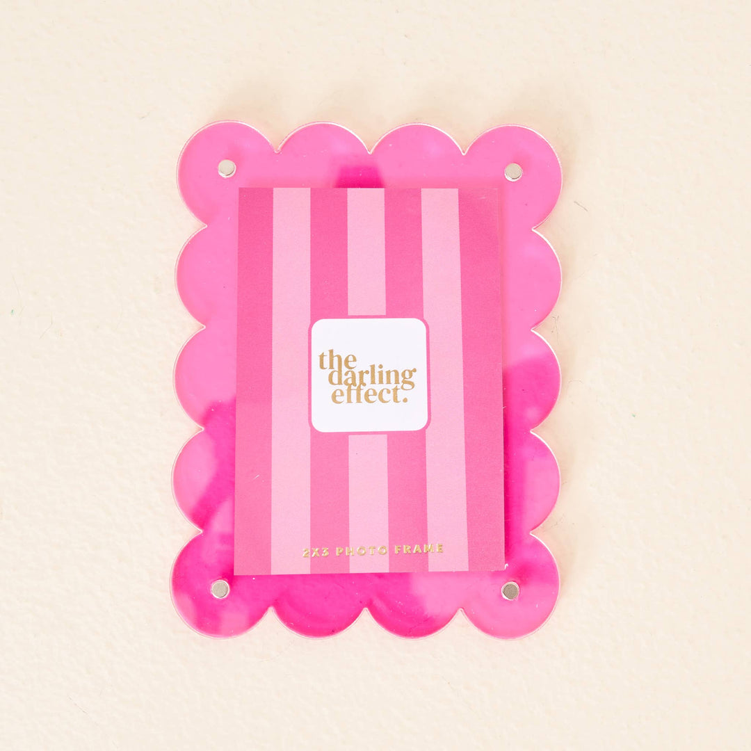 Mini acrylic frame magnet in hot pink with scallop edges, gold text, and four corner holes. Size: mini.